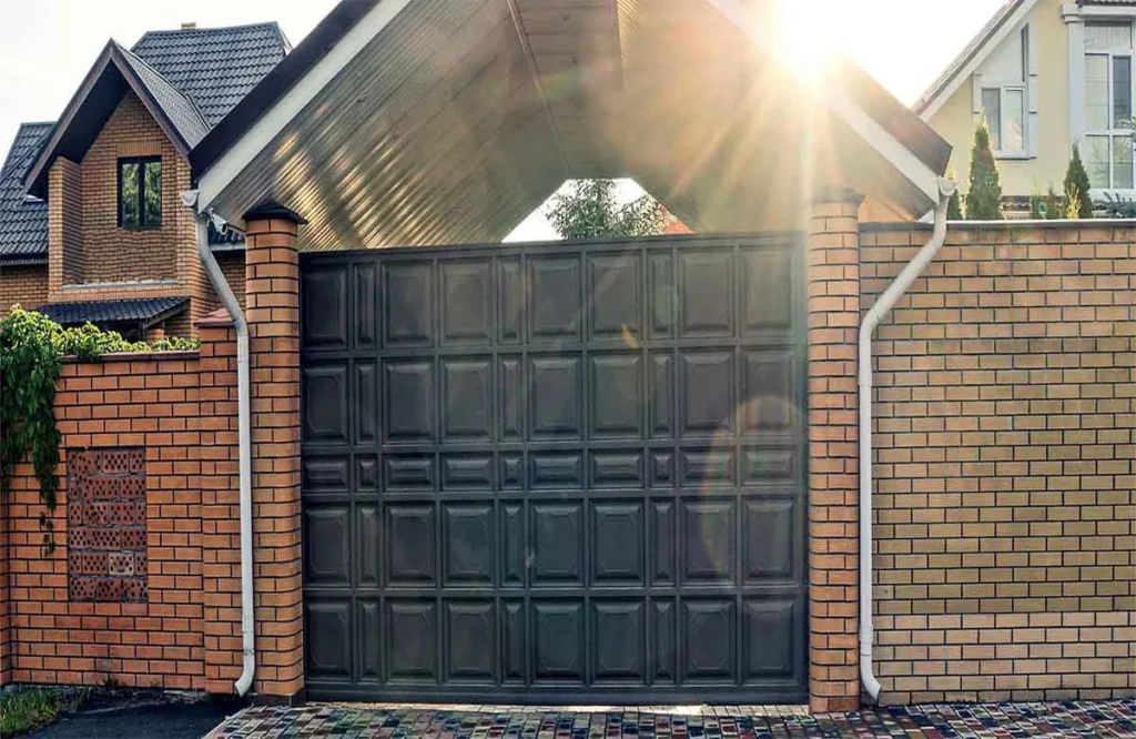 Secure residential driveway gate under a covered entry, highlighting reliable gate repair services in Houston for modern homes